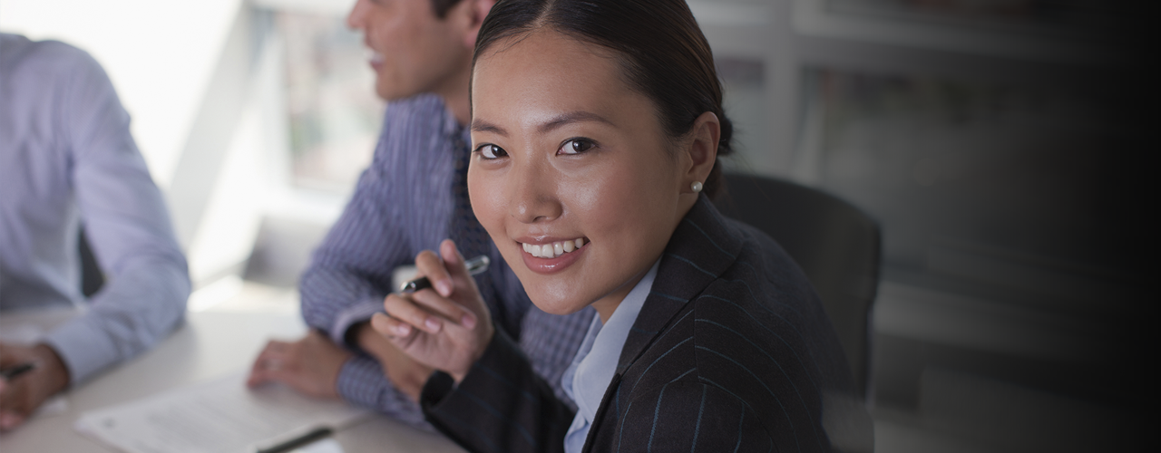 professional woman in meeting smiling at camera